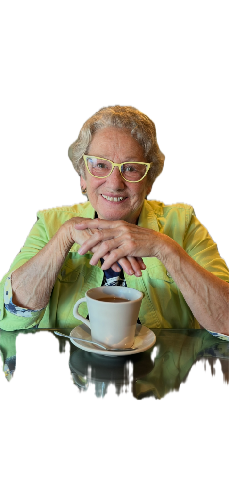 A smiling, older woman in glasses, wearing a yellow jacket.Visible details: A pink, newfashioned eyeglasses, yellow semi-r...